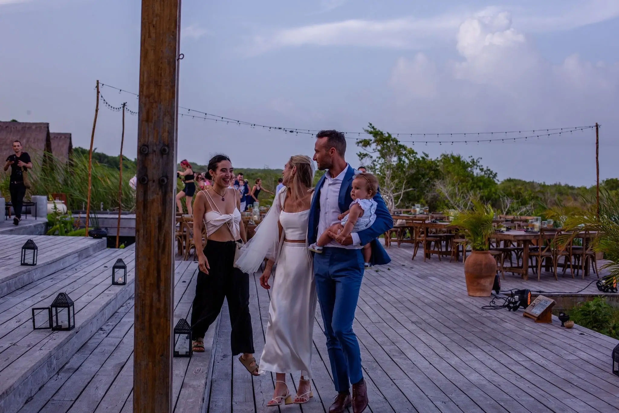 Newlyweds and guests enjoying a stylish outdoor reception organized by a Tulum wedding planner